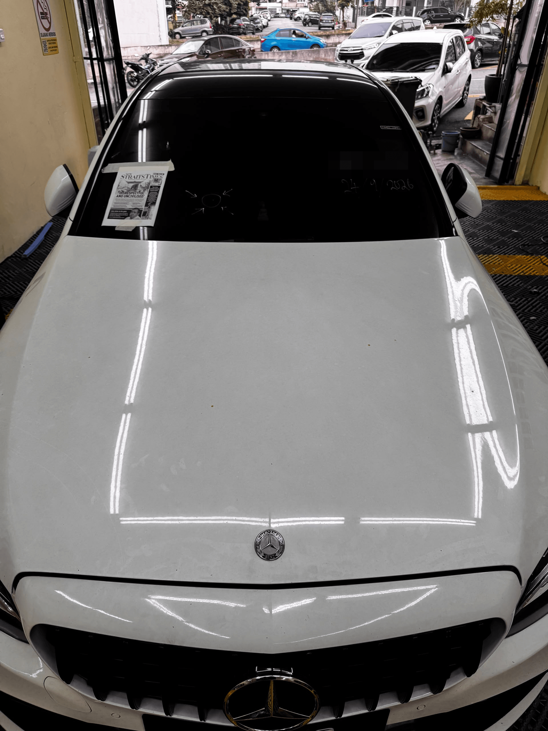 Windscreen sebelum ditukar pada Mercedes putih di SIFU CERMIN Cheras, dengan tanda pada kaca.
