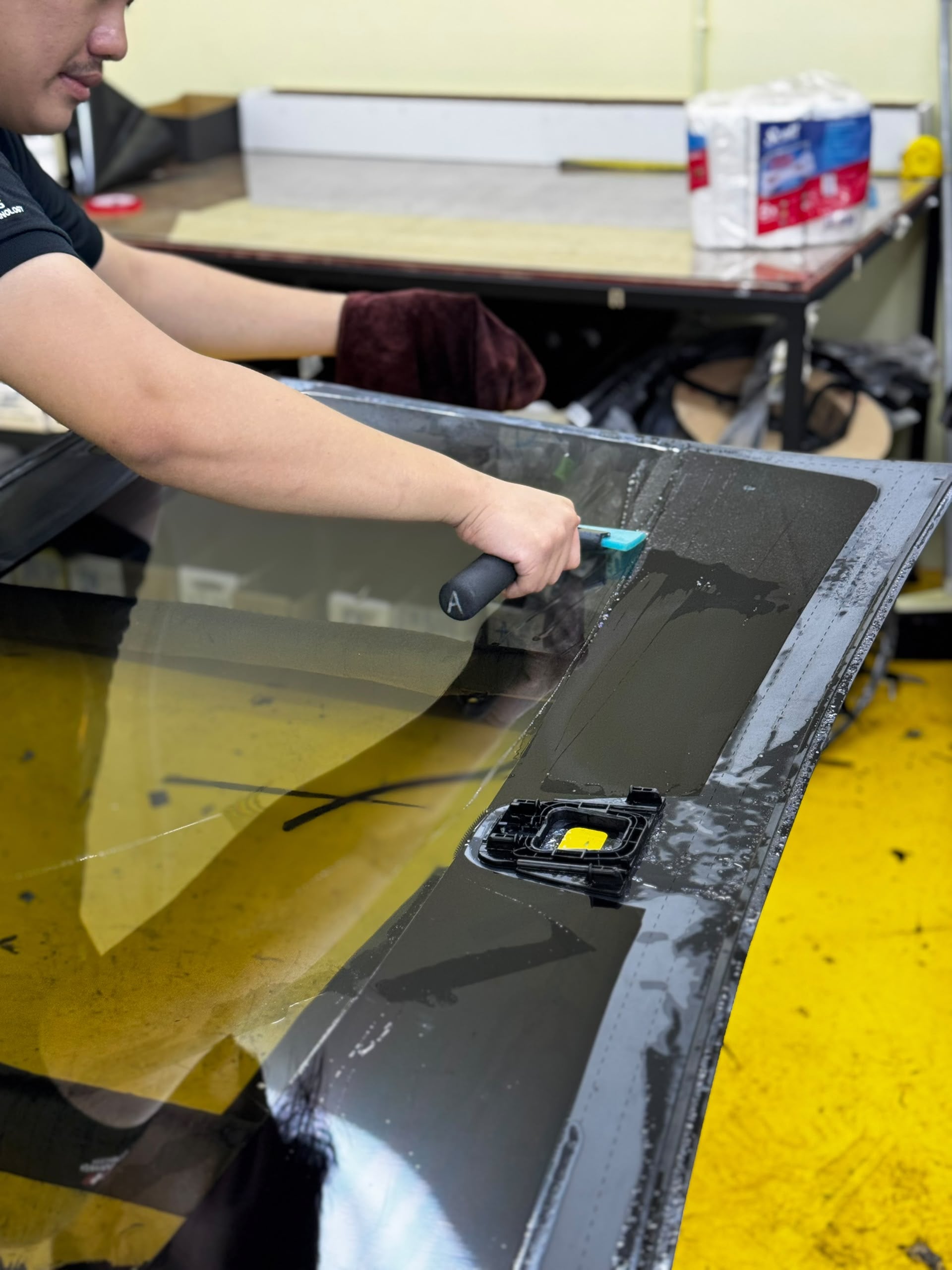 Teknisi memasang tinted pada windscreen di SIFU CERMIN Cheras.